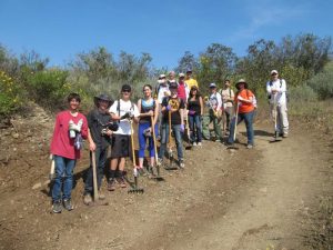 CORBA volunteers pose in front of the ditch to keep rain water off the chicane near the bottom of the Lizard Rock Trail.
